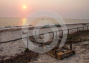 Sunrise over beach with dog and fishing boats