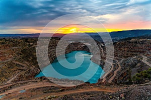 Sunrise over the blue quarry lake in the shape of a heart. Limestone fluxing of Kadykovo quarry, Balaklava, Crimea. A