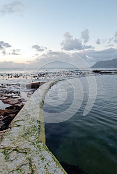 Sunrise over Dale Brook Tidal Swim Pool seawall in Cape Town South Africa SA