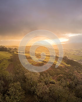 Sunrise over Denbighshire hills, Wales, as the sun breaks clouds.