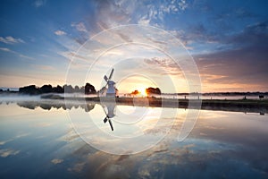 Sunrise over Dutch windmill and river