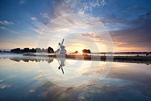 Sunrise over Dutch windmill and river