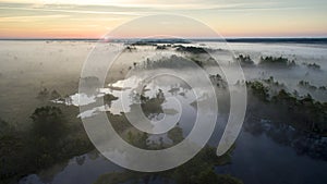 Sunrise over the fog in a lake in Tolkuse bog, Luitemaa Nature reserve, Estonia