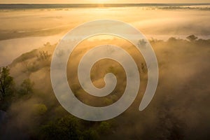 Sunrise over foggy riverbank. Fog on river aerial view. Misty river in sunlight from above