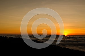 Sunrise over foggy valley mountains