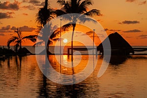 Sunrise over the Gulf of Mexico reflected into the infinity pool at the resort