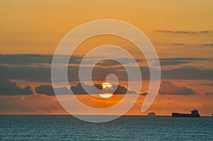 Sunrise over the Indian Ocean with ships and clouds