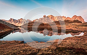 Sunrise over Lac Long with Massif des cerces reflection on the lake in Claree valley at French Alps, France