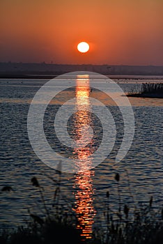 Sunrise over the lake, reflection of the red rays of the sun in the water, Ukraine, Tiligulsky estuary