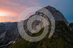 Sunrise over Mangart mountain with dramatic reddish sky, Julian Alps, Mangart Pass, Slovenia, Triglav national park, Europe