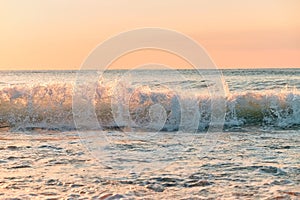 A sunrise over the ocean with crashing waves