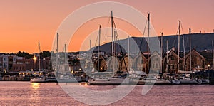 Sunrise over Old Venetian port and harbour of Chania, Crete, Greece. Sailing boats, pier, Old Venetian shipyards and