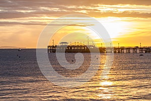 Sunrise over pier in bay