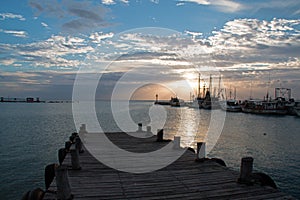 Sunrise over Puerto Juarez Cancun Mexico fishing boats / trawler and docks and pier and jetty and seawall