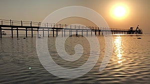 Sunrise over the Red Sea in Egypt. Sunny road over the pier.