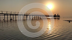 Sunrise over the Red Sea in Egypt. Sunny road over the pier.
