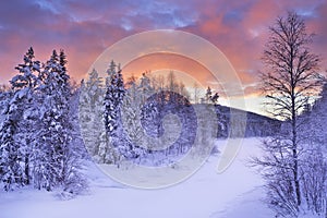 Sunrise over a river in winter in Finnish Lapland