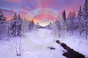 Sunrise over a river in winter near Levi, Finnish Lapland