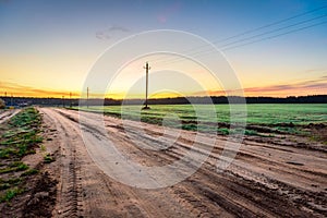 Sunrise over rural meadow field and country open road