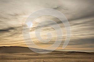 Sunrise over a sandy beach with the ocean in the background