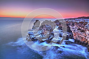 Sunrise over the sea and rocky shore