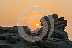 Sunrise over the sea and stone at the seaside of Mount Putuo in the morning, an island southeast of Shanghai in Zhoushan, Zhejiang