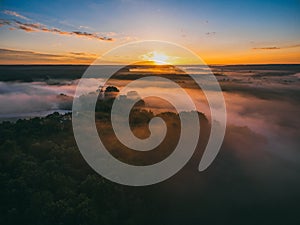 Sunrise over spring meadow. Spring aerial landscape. Spring sunrise over green forest and field with river and fog.