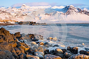 Sunrise over stunning mountain landscape in Iceland, Ocean coast with volcanic rocks and yellow grass, Pure nature at