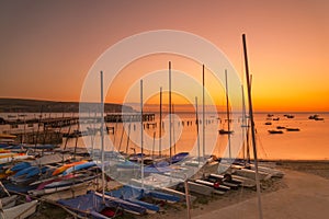 Sunrise over Swanage piers illuminated by the orange pre-dawn