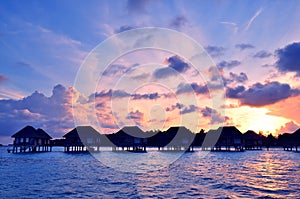 Sunrise over water bungalows in Maldives