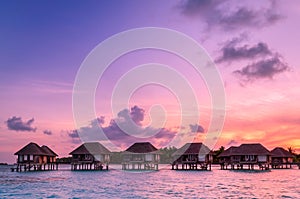 Sunrise over water bungalows in Maldives