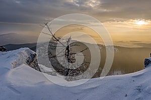 Panoráma východu slnka, farebná obloha, zimné snehové mraky v prírodnej krajine Slovenska.