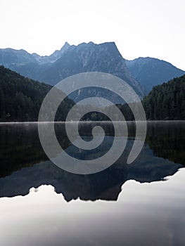 Sunrise panorama mirror reflection view of alpine forest mountain lake Piburger See Oetztal Alps Tyrol Austria Europe