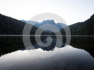 Sunrise panorama mirror reflection view of alpine forest mountain lake Piburger See Oetztal Alps Tyrol Austria Europe