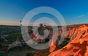 Sunrise panoramic view to Goreme city and flying balloons, Cappadocia, Turkey