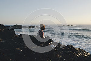 sunrise with people sitting on a rock