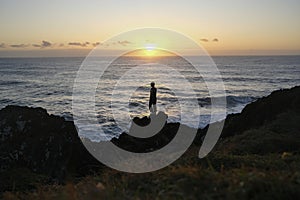 sunrise with people standing on a rock