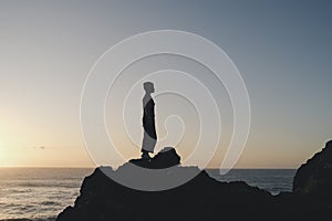 sunrise with people standing on a rock