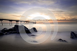 Sunrise on the Pont del petroli beach with silky water.