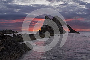 Sunrise with red clouds at bow fiddle rock near Portknockie
