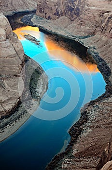 Sunrise reflection on Colorado River surface at Horseshoe Bend in Arizona