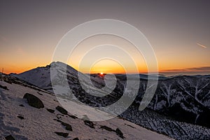 Východ slnka na hrebeni v zasnežených horách, Slovensko Nízke Tatry, dumbier