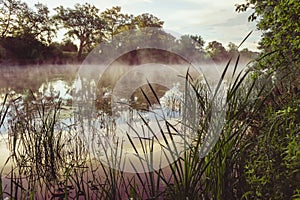 Sunrise on a river with a mist over the water