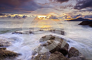 Sunrise at rocky beach in terengganu, malaysia. image taken with long exposure,custom white balance