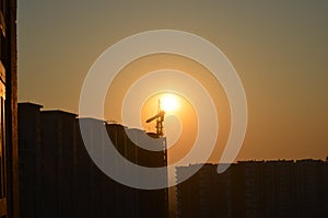 Sunrise scene housing society construction site crane machinary orange Sun and Skyline silhouette morning dawn day photography.