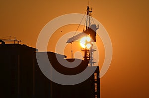 Sunrise scene housing society construction site crane machinary orange Sun and Skyline silhouette morning dawn day photography.