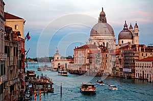 Sunrise scenery of Venice bathed in golden morning twilight, with boats & ferries cruising on Grand Canal