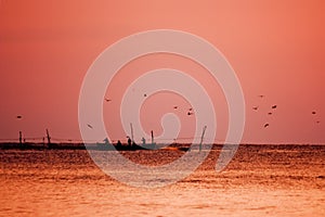 sunrise at sea, boats with fishermen fishing