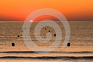 Sunrise at Sea with Buoys photo