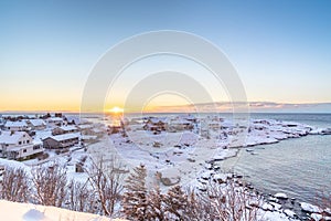 Sunrise from the sea in snowy quiet village in the north.